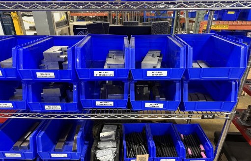 Shelves of blue bins holding parts